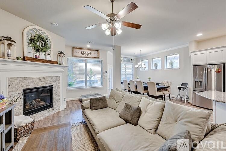 A living room with a beige couch and a fireplace.