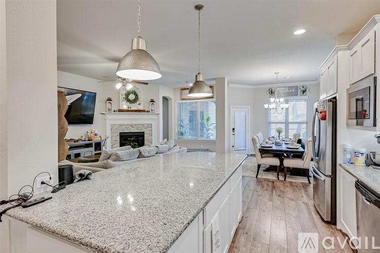 A kitchen with a granite countertop and a dining area with a table and chairs.