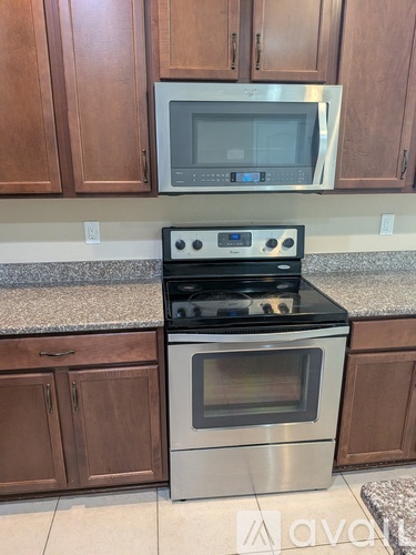 A kitchen with a stove and microwave above it.