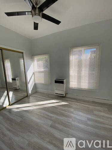 A room with a ceiling fan and a large mirror.