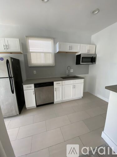 A kitchen with white cabinets and appliances.