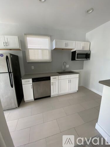 A kitchen with white cabinets and appliances.