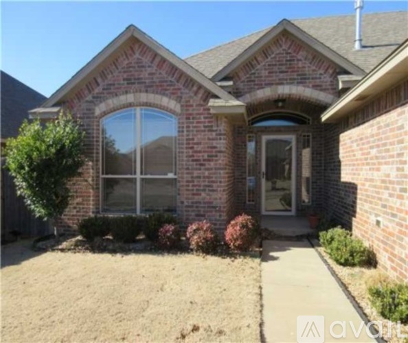 A house with a brick facade and a large arched window.