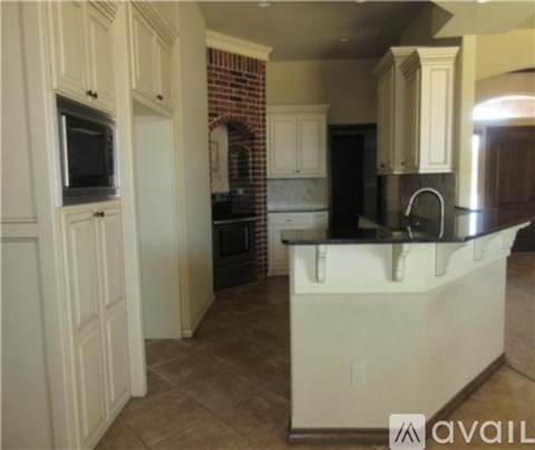 A kitchen with white cabinets and a brick wall.
