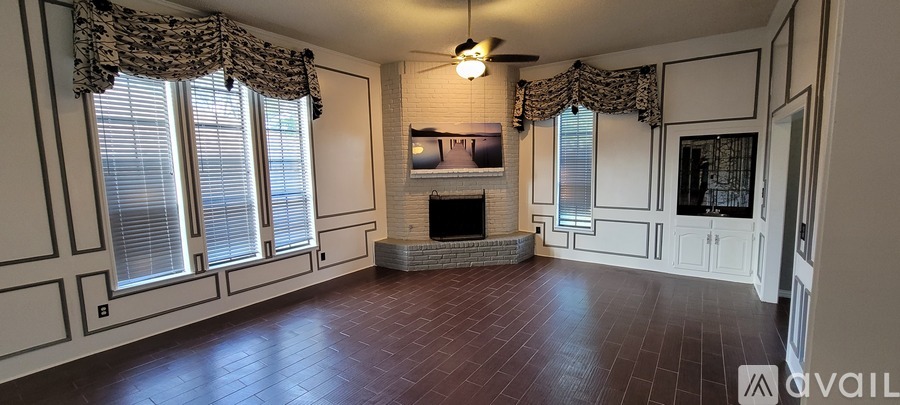 A living room with a fireplace and a flat screen TV.