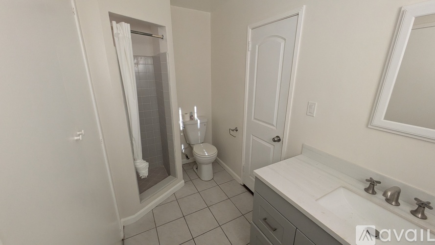 A bathroom with a toilet, sink, and shower.
