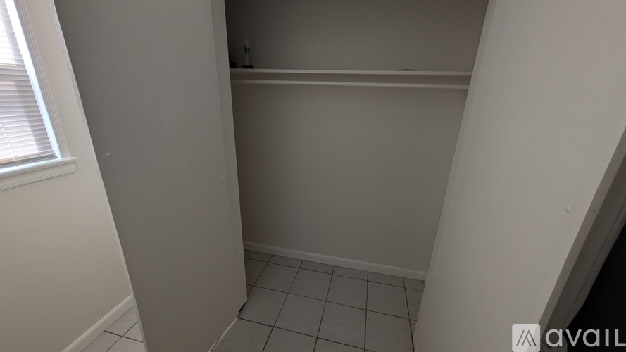 A small, empty room with white walls and tiled flooring.