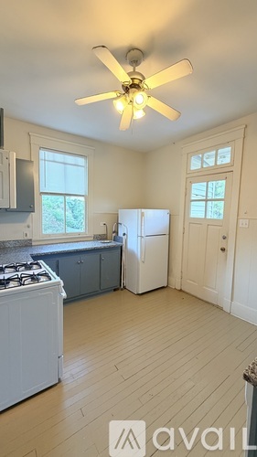 A kitchen with a white stove top oven and a white refrigerator.