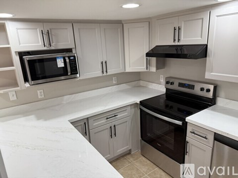 A kitchen with white cabinets and a black stove top oven.