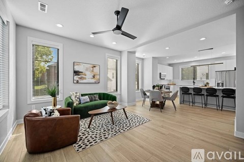 A living room with a brown leather couch and a green sofa.