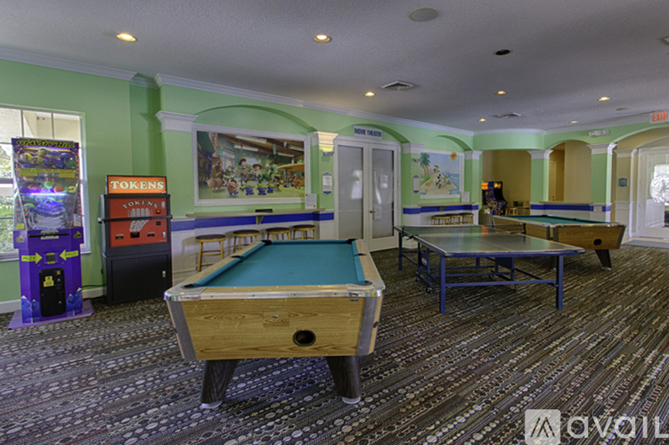 A room with a pool table and a pinball machine.