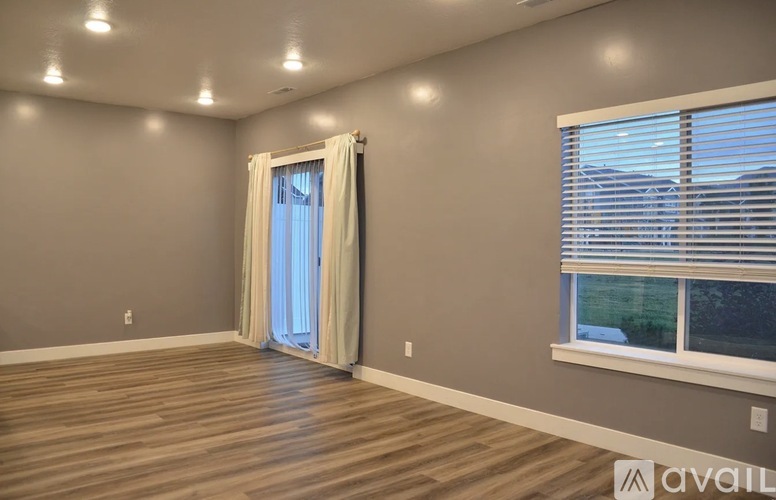 A room with a window and a door with curtains.