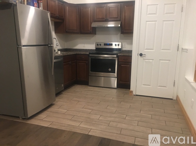 A kitchen with a refrigerator, oven, and microwave.