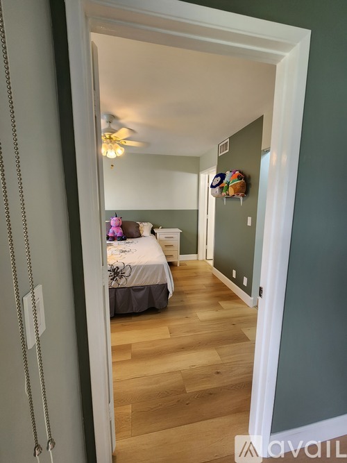 A bedroom with a bed and a ceiling fan.