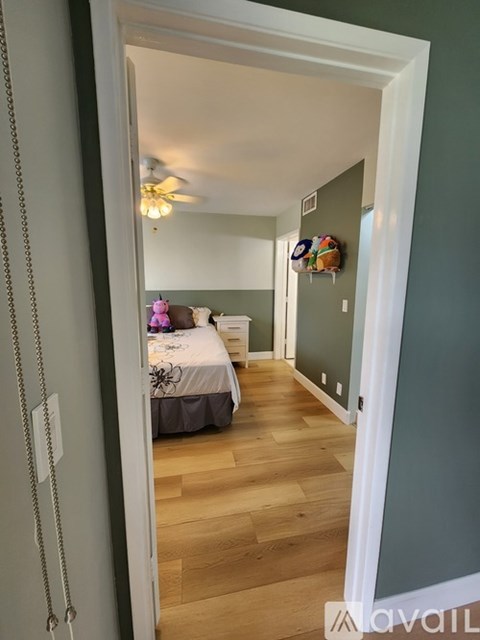 A bedroom with a bed and a ceiling fan.