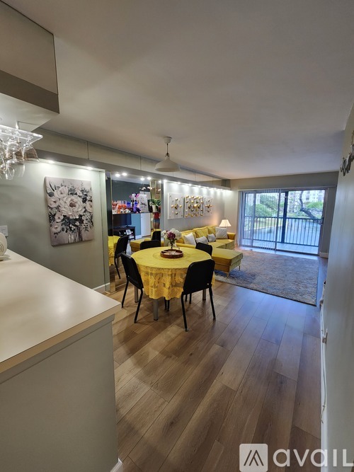 A dining room with a table set for four and a chandelier hanging from the ceiling.