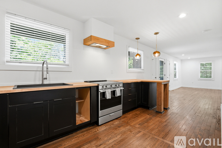 A kitchen with black cabinets and a wooden island.
