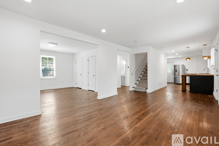A spacious room with wooden floors and white walls.