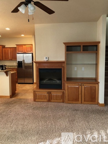 A living room with a fireplace and a refrigerator.