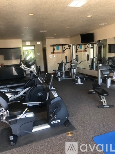 A gym with a variety of equipment including treadmills, weights, and exercise machines.