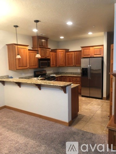 A kitchen with wooden cabinets and a granite countertop.
