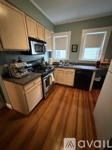 A kitchen with wooden floors and a black stove top oven.