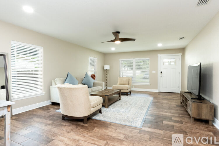 A living room with a beige sofa, a wooden coffee table, and a ceiling fan.