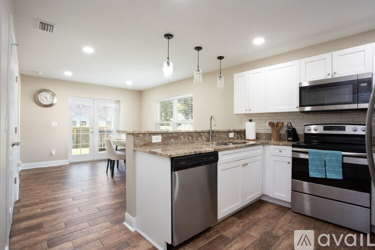 A kitchen with a granite countertop and stainless steel appliances.