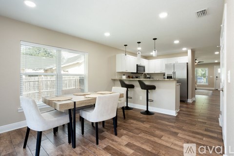 A kitchen with a table and chairs in front of a window.