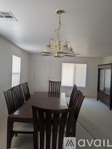 A dining room with a table and chairs and a chandelier.