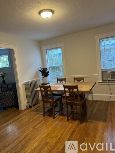 A dining room with a wooden table and chairs.