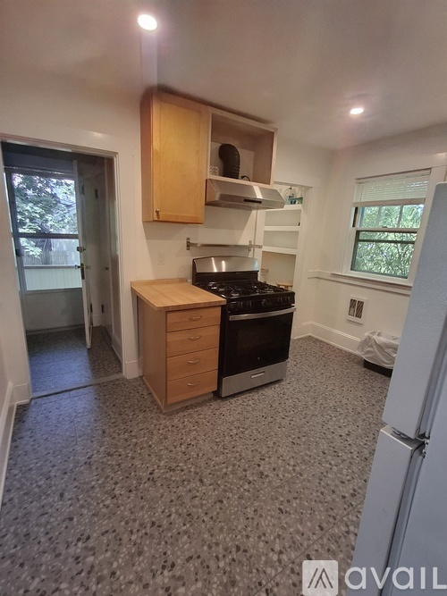 A kitchen with a stove top oven and a refrigerator.