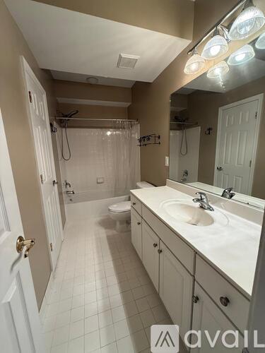 A bathroom with a white sink, toilet, and a shower with a glass door.