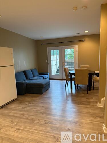 A living room with a couch, chairs, and a dining table.