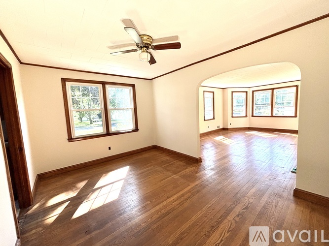 A room with wooden floors and a ceiling fan.