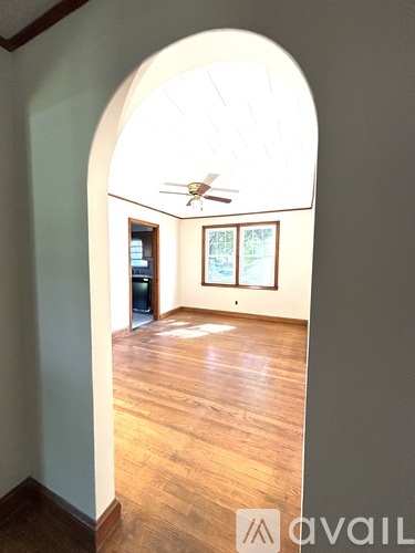 A room with wooden floors and a ceiling fan.