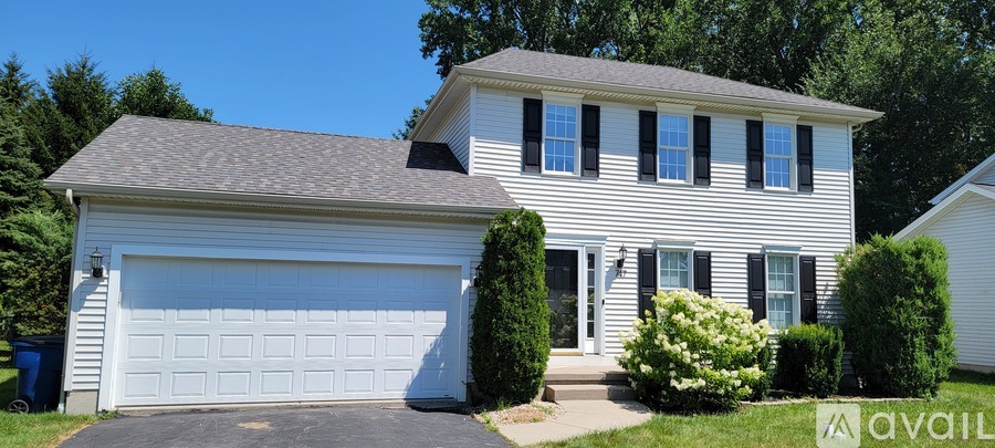 A two-story house with a white garage door.