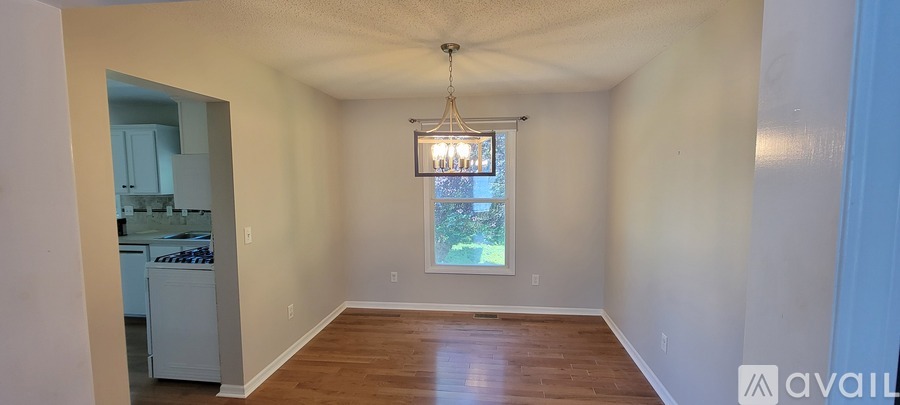 A room with a window and a chandelier.