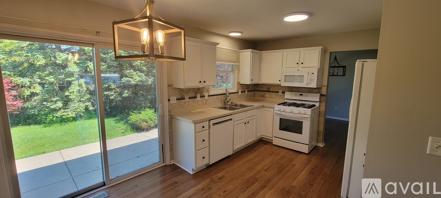 A kitchen with white cabinets and a wooden floor.