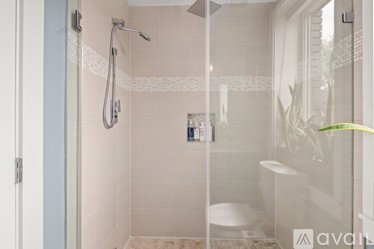 A bathroom with a glass shower door and a white toilet.