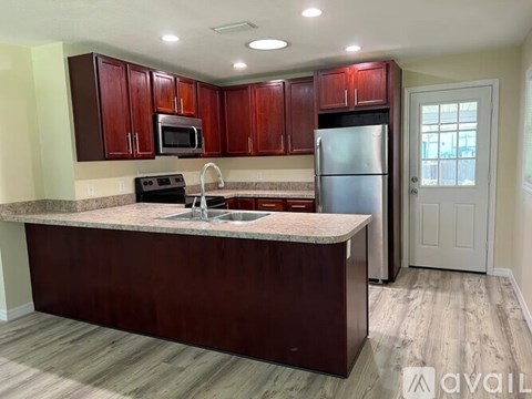 A kitchen with brown cabinets and a marble countertop.