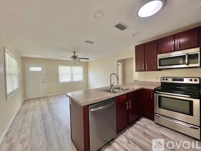 A kitchen with a stove top oven and a microwave above the sink.