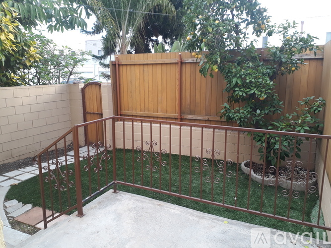 A backyard with a wooden fence and a metal railing.