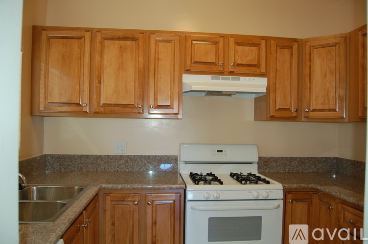A kitchen with wooden cabinets and a white dishwasher.