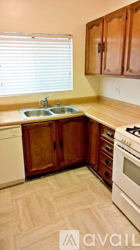 A kitchen with wooden cabinets and a white dishwasher.