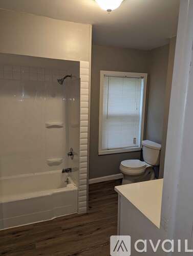 A bathroom with a white tub and toilet.