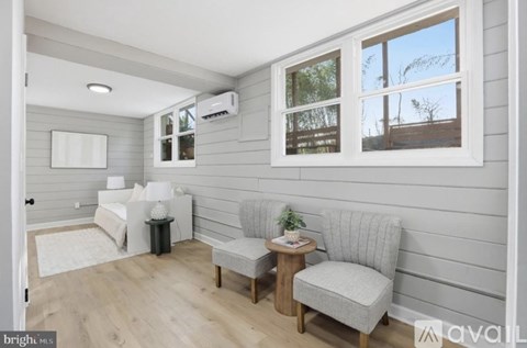 A living room with a grey sofa, a white couch, and a small table with a plant on it.