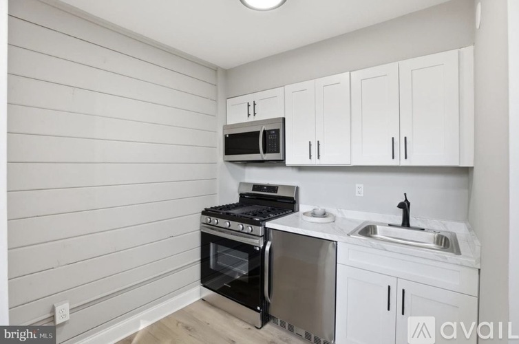 A kitchen with white cabinets and a black stove top oven.