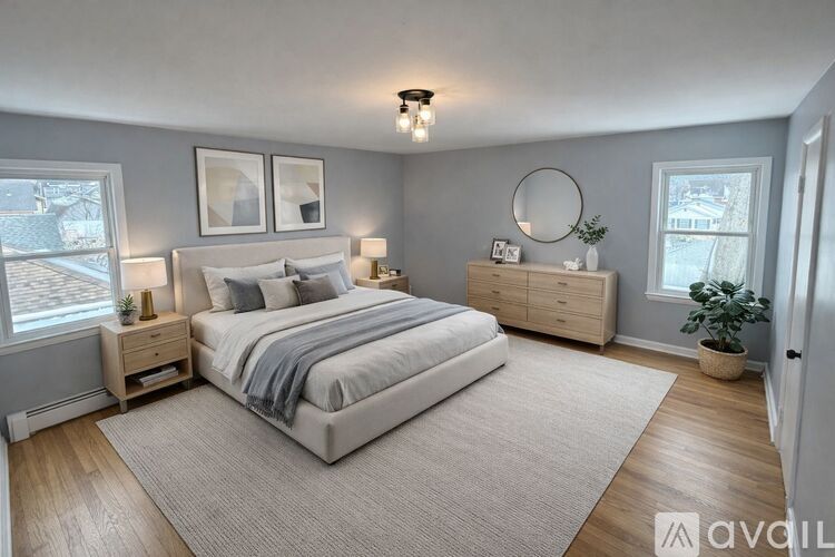 A bedroom with a large bed, nightstands, and a plant.