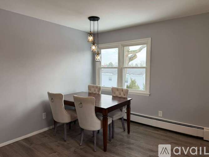 A dining room with a table and chairs.